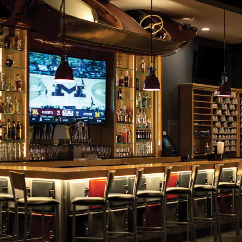 Bar, shelving with liquor, large screen tv and bar seating
